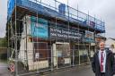Cllr Paul Bradley by the eyesore shops where fencing and scaffolding has gone up