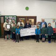 Scouts, Beavers and Cubs from 2nd Cradley Scouts hand over their donation to the Friends of Homer Hill Park