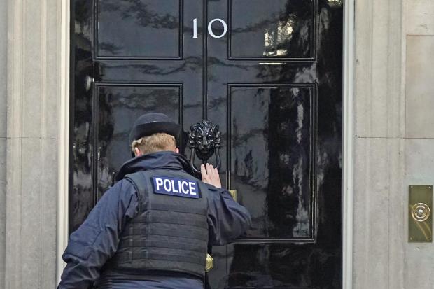 A police officer knocks on the door of the Prime Minister’s official residence in Downing Street