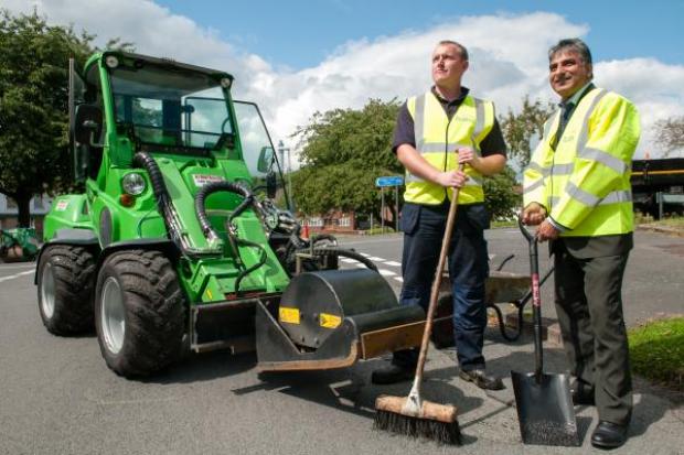 Roadworker Liam Bryant and Councillor Khurshid Ahmed get to grips with the new pothole mending equipment